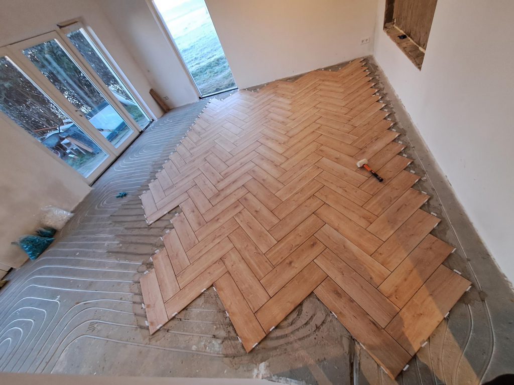 Keramische tegels op de vloer leggen stad.Denekamp